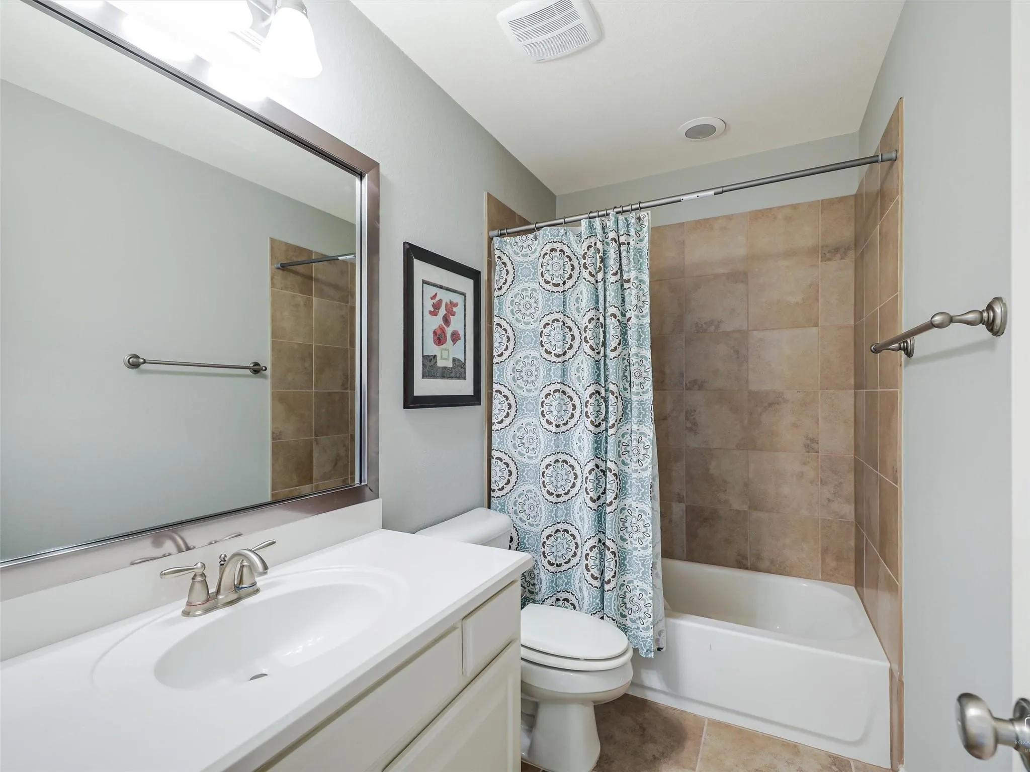 White vanity with integrated sink, brushed nickel faucet, and framed mirror