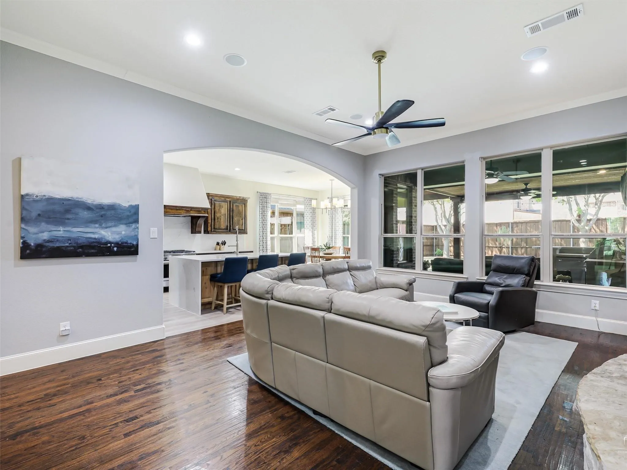 Wood-finish flooring, recessed lighting, crown molding, and large windows