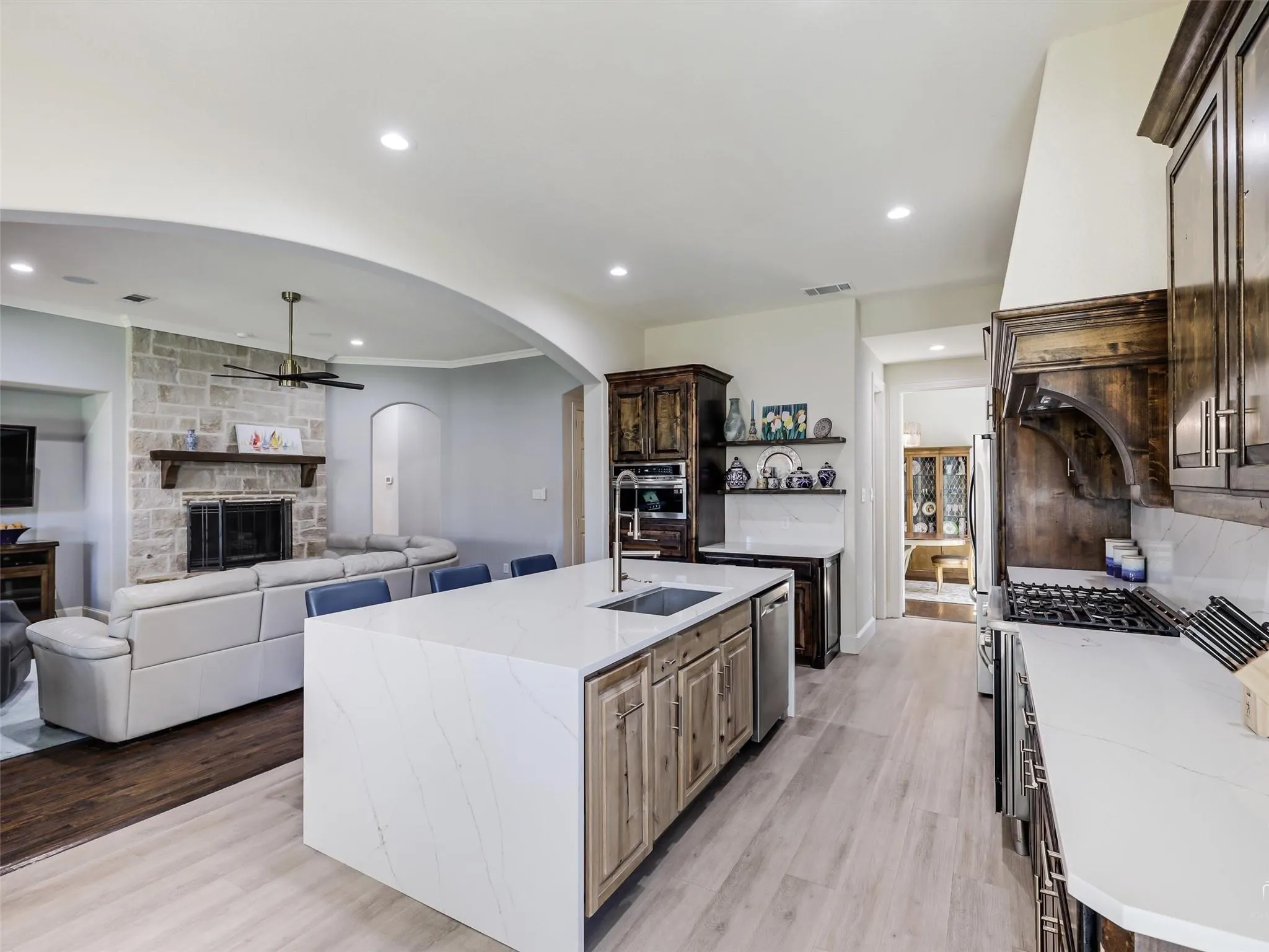 Kitchen featuring a central island with countertop seating, integrated sink, and dishwasher