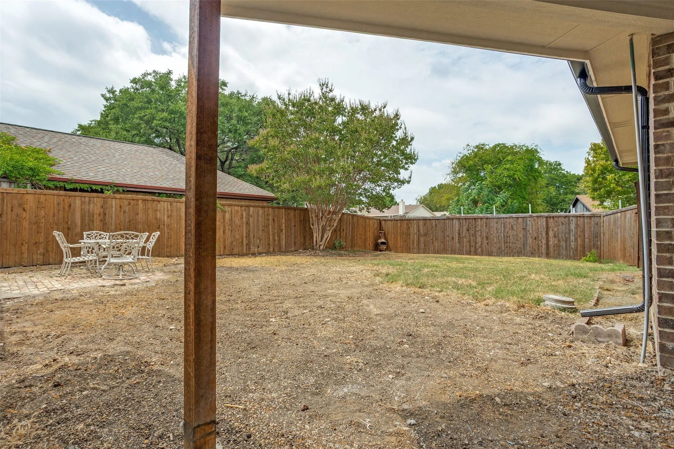 Private backyard space featuring a wood fence perimeter and a brick paver patio