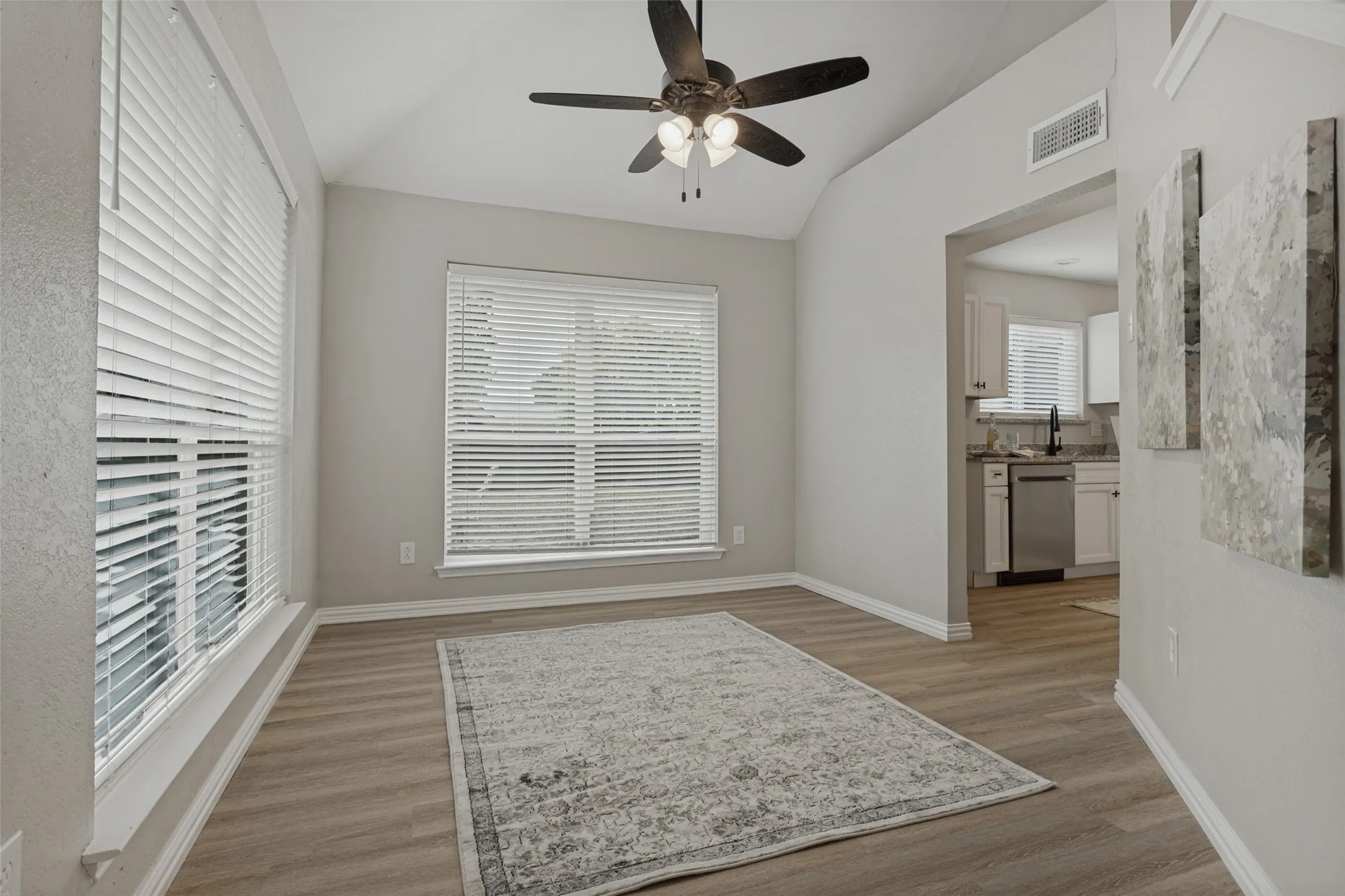 Lots of natural light in this dining area! Lighted ceiling fan and easy-care luxury vinyl plank flooring.