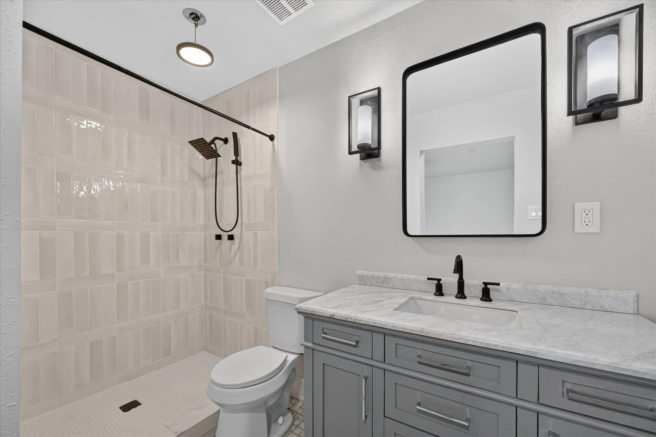 Walk-in shower with textured tile surround and rainfall showerhead