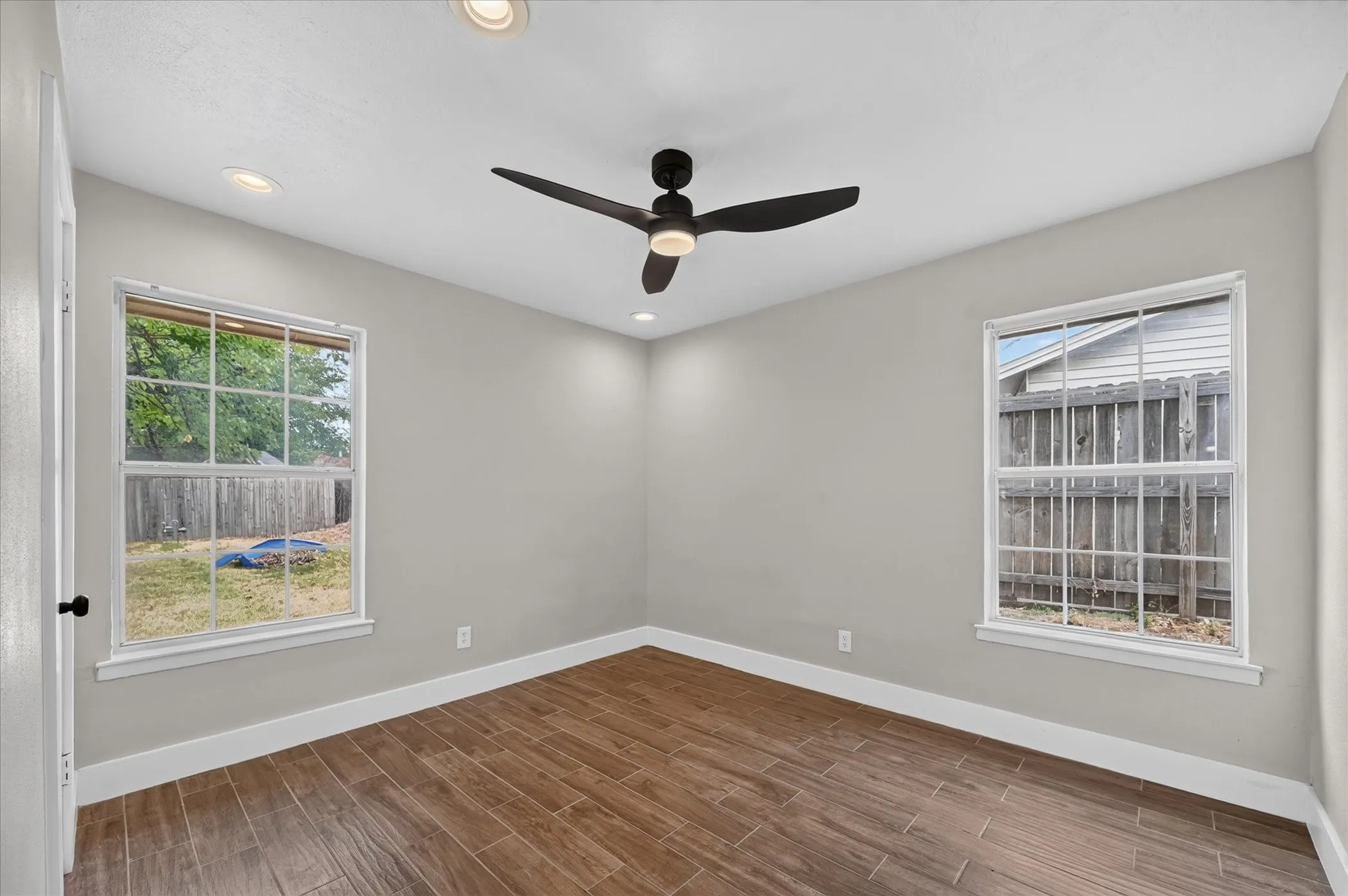 Recessed lighting, ceiling fan, wood-finish flooring, two windows, painted walls