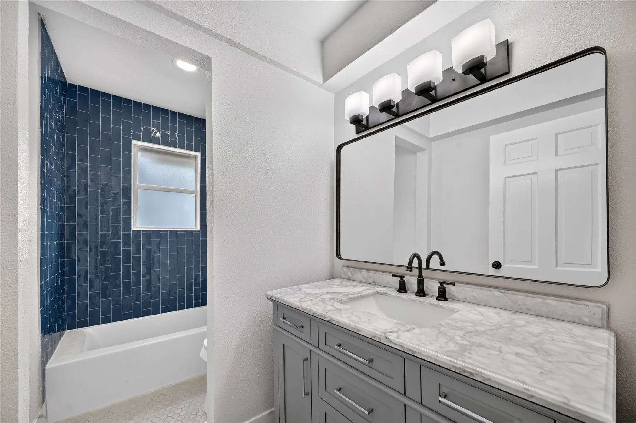 Built-in vanity with a stone countertop and an undermount sink