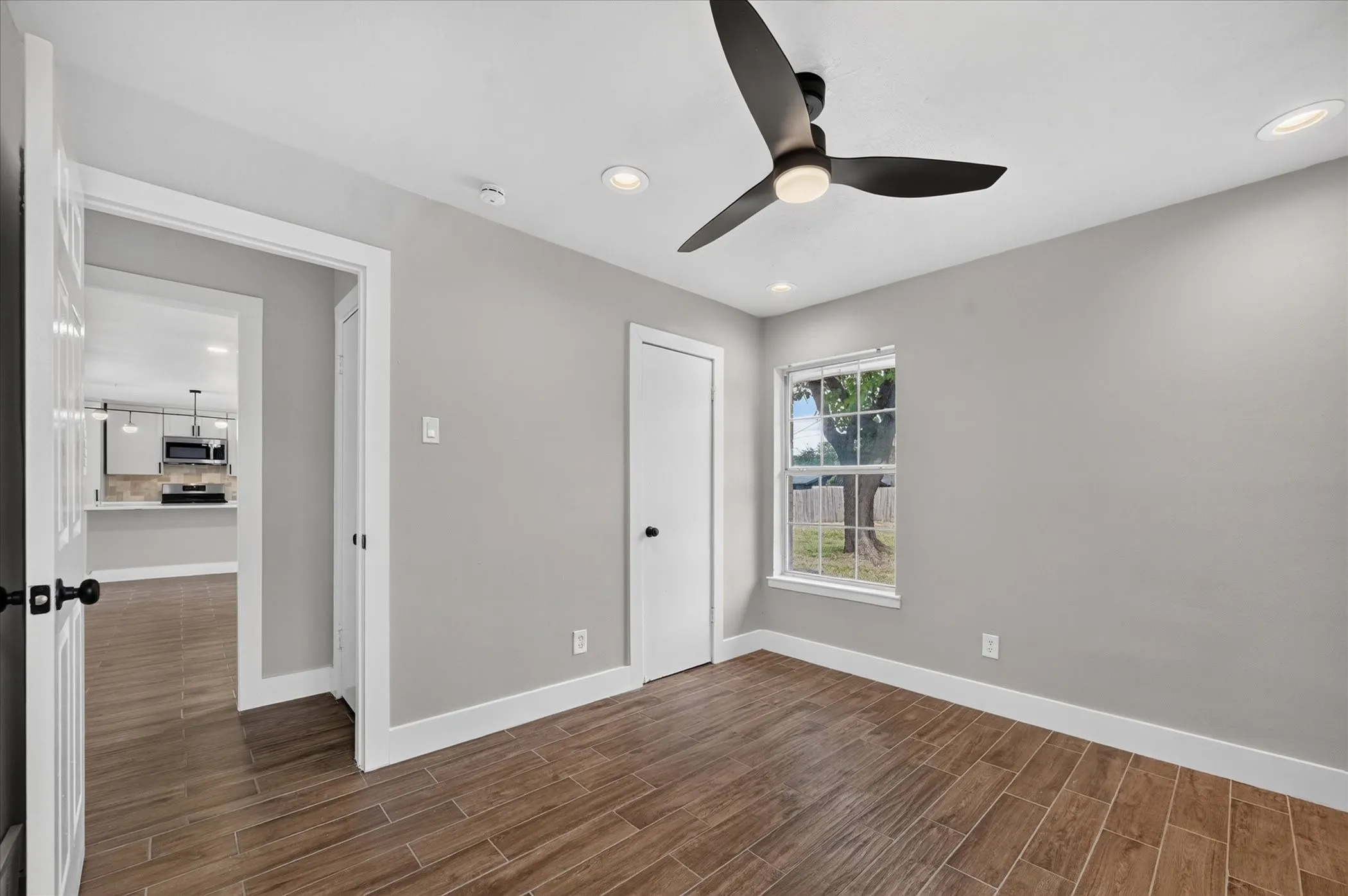 Wood-finish flooring, recessed lighting, and a contemporary ceiling fan