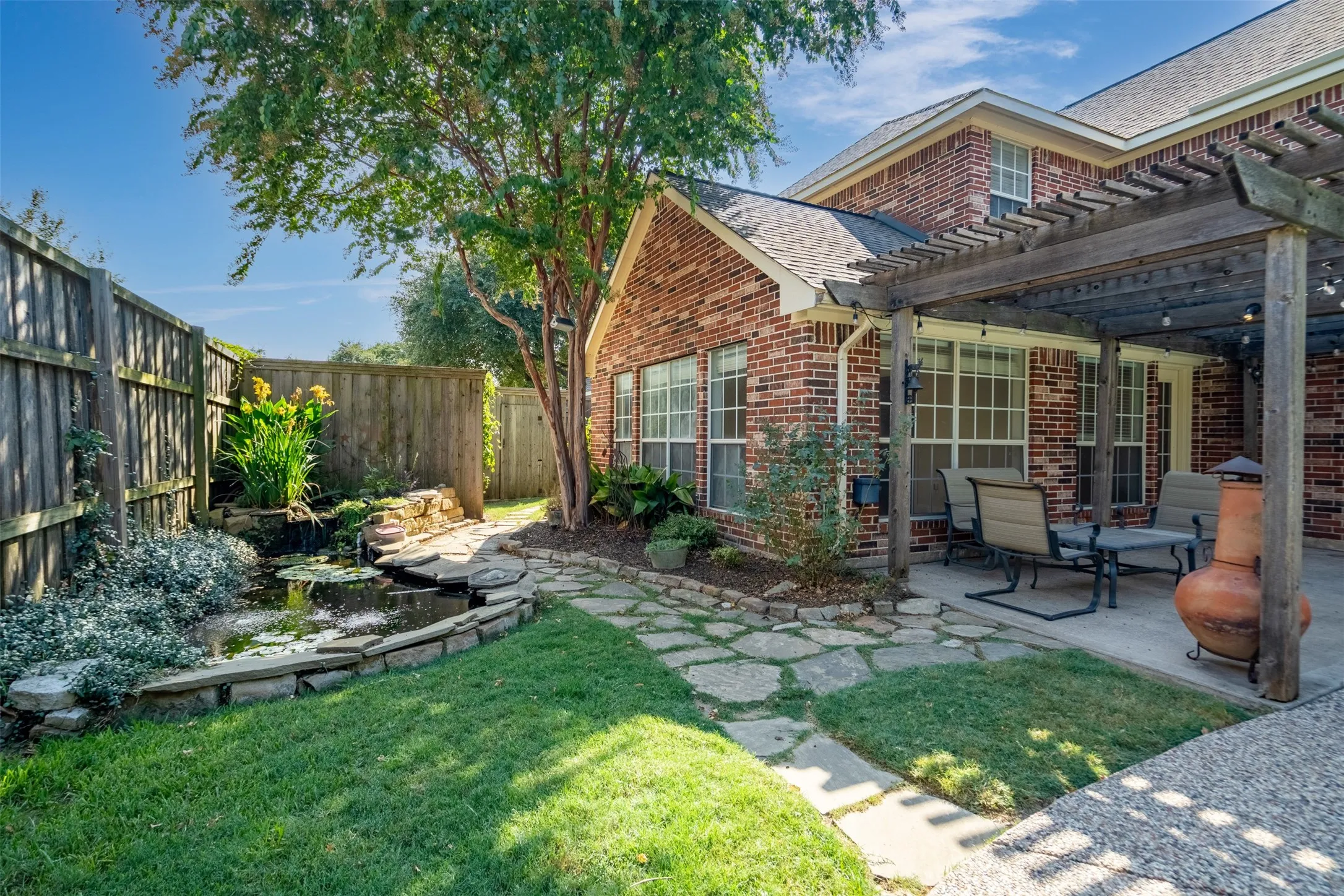 Brick exterior with multiple windows and a covered patio