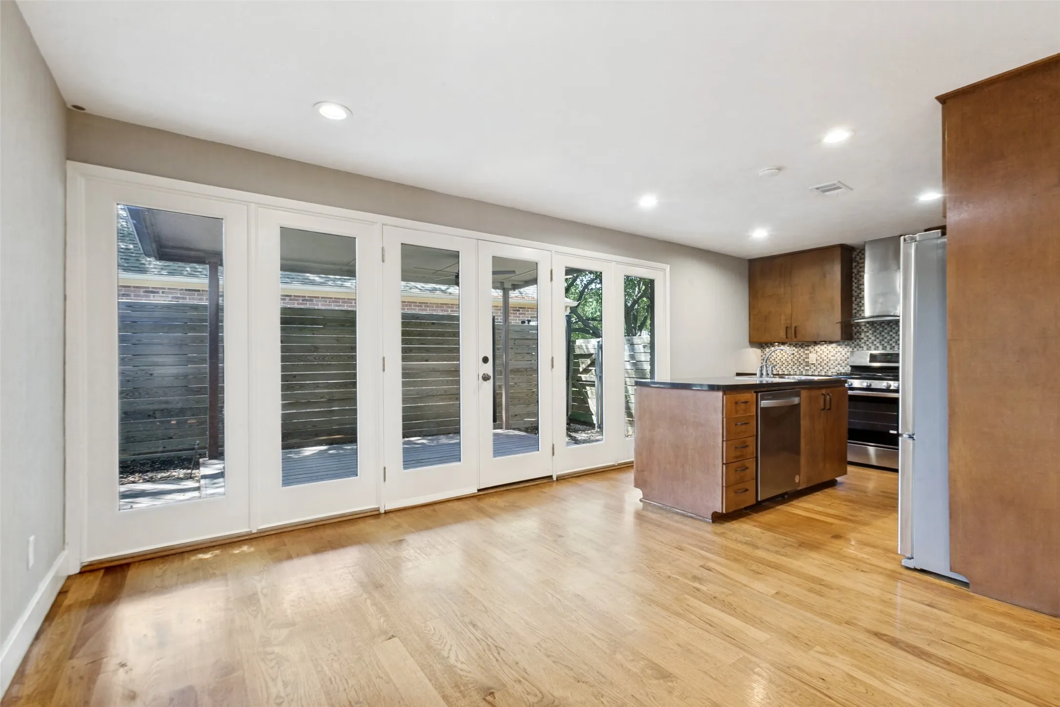 Hardwood flooring throughout, recessed lighting, and a kitchen island with integrated dishwasher