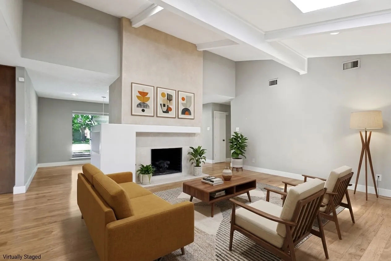 Vaulted ceiling with exposed beams, wood-finish flooring, fireplace with a hearth, and a skylight