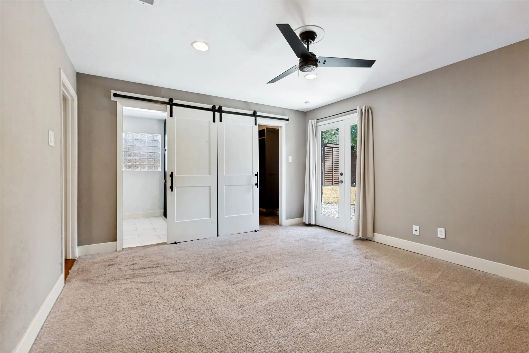 Neutral-toned carpeting throughout, complemented by a contemporary ceiling fan