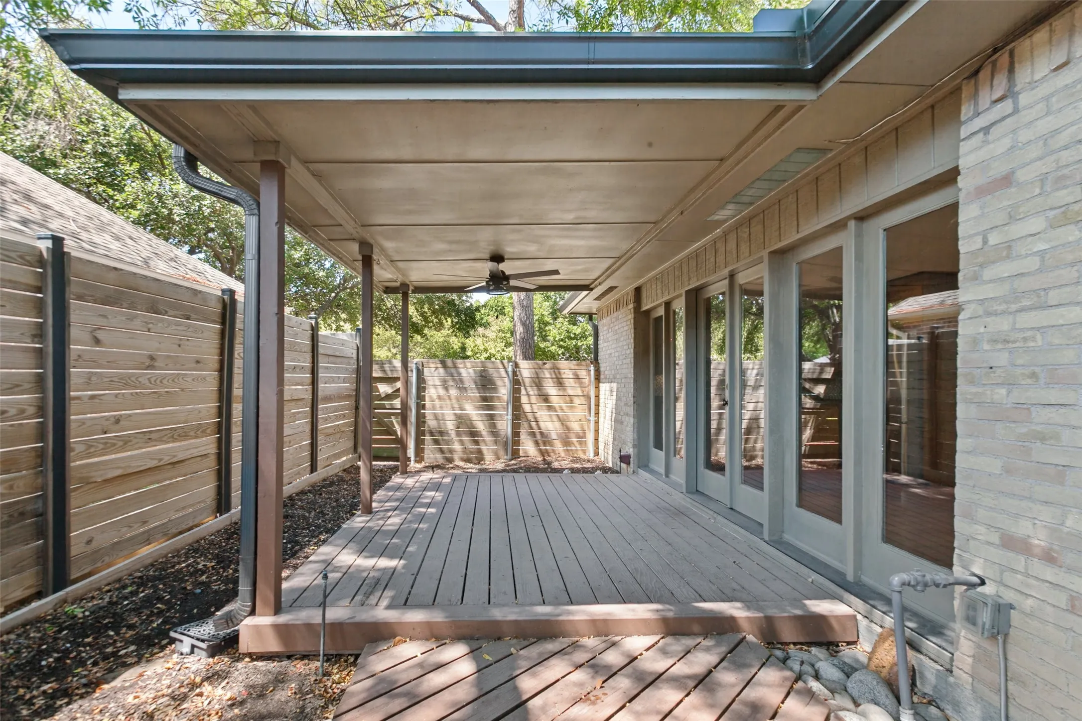 Covered patio featuring wood-finish decking and integrated ceiling fan