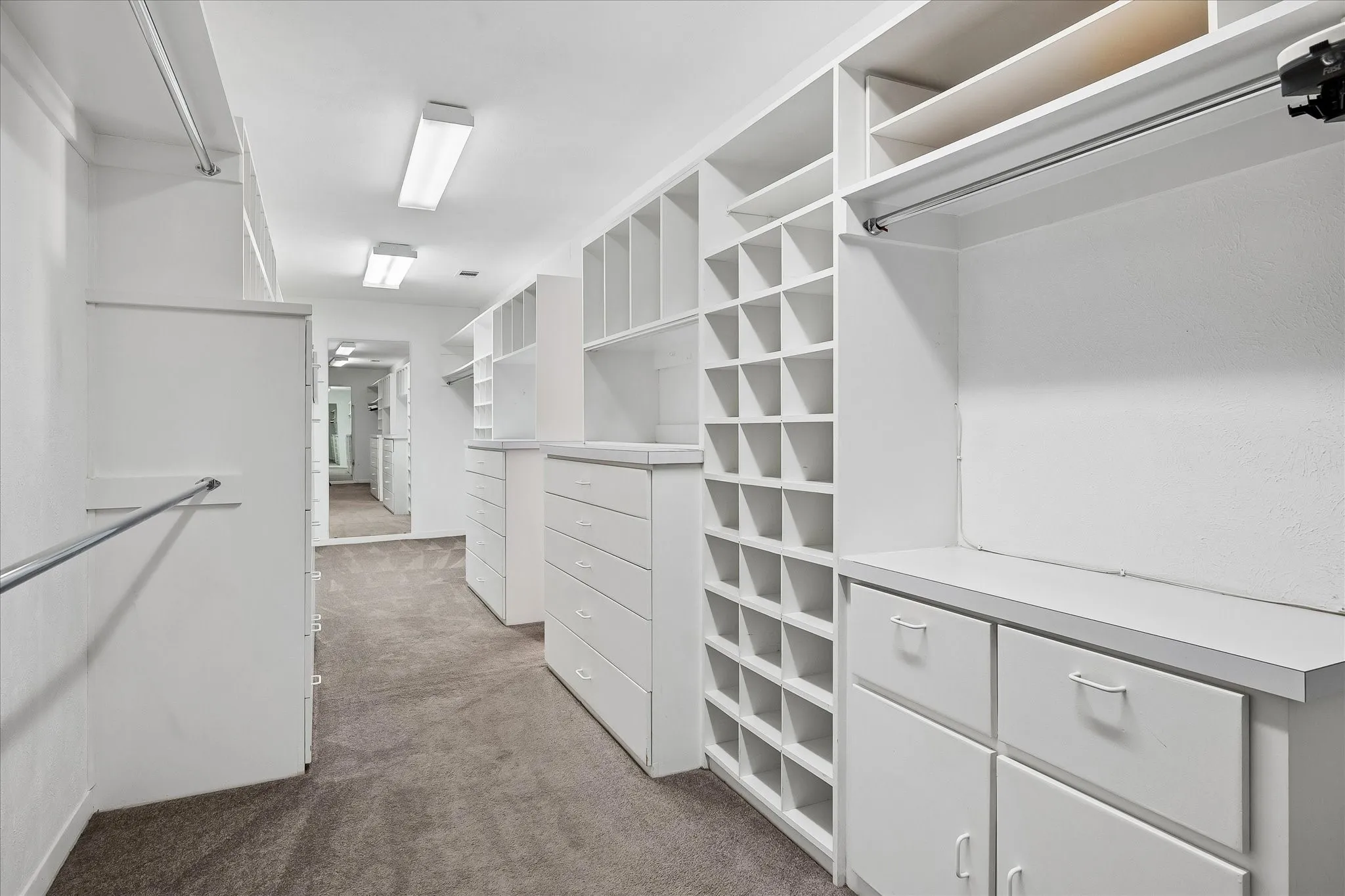 Massive Primary custom walk-in closet with built-in drawers, shelving, and cubby storage.