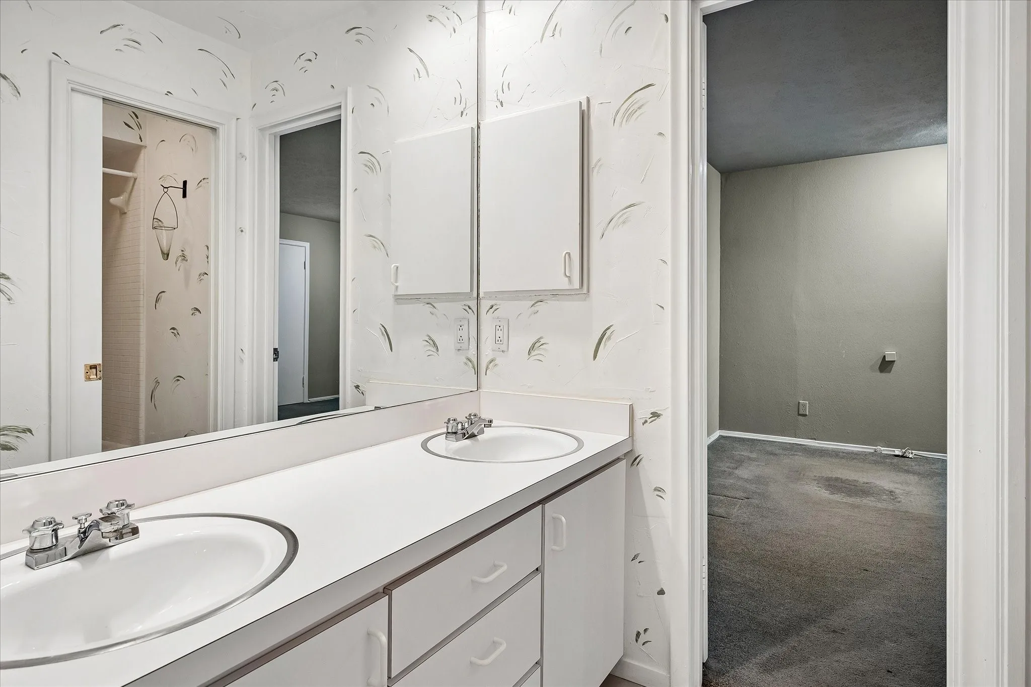 Dual-sink Jack-and-Jill bathroom connecting two bedrooms, with a separate shower.