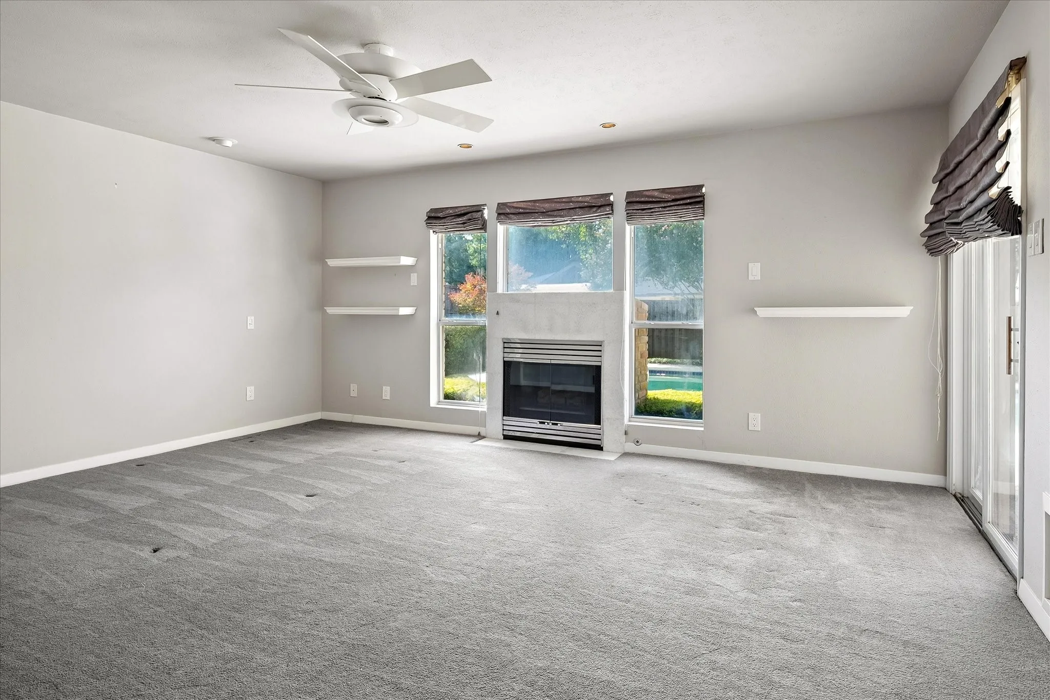 Spacious Primary with gas fireplace and sliding door access to pool.
