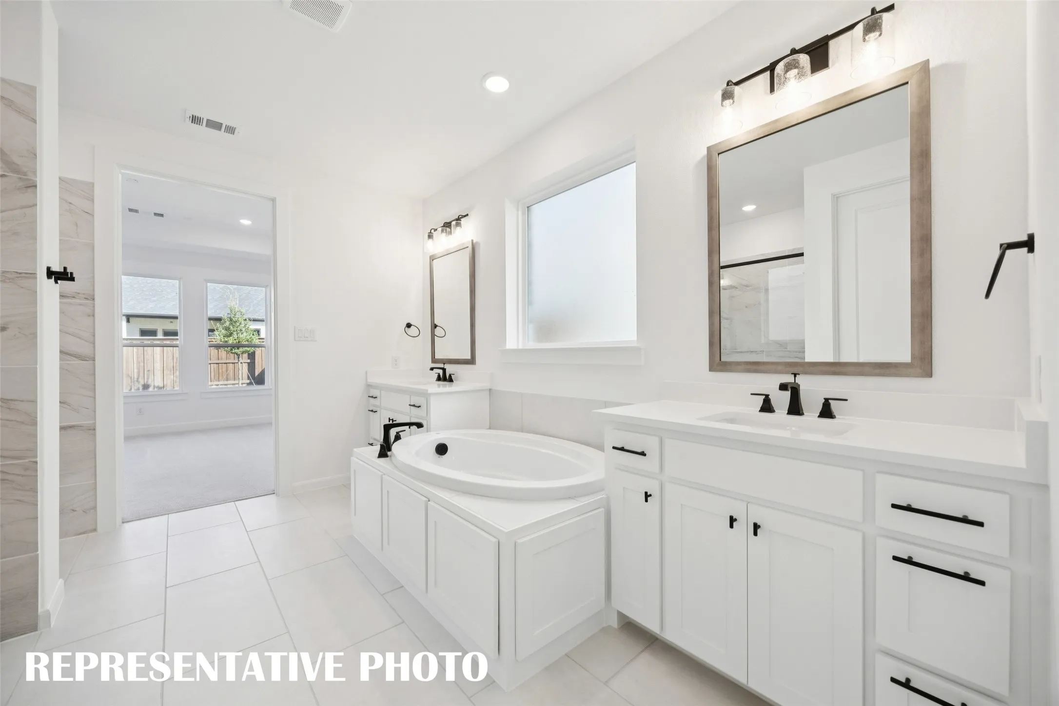 With his and her vanities and a relaxing tub, this owner's bath was designed for luxury and comfort.  REPRESENTATIVE PHOTO