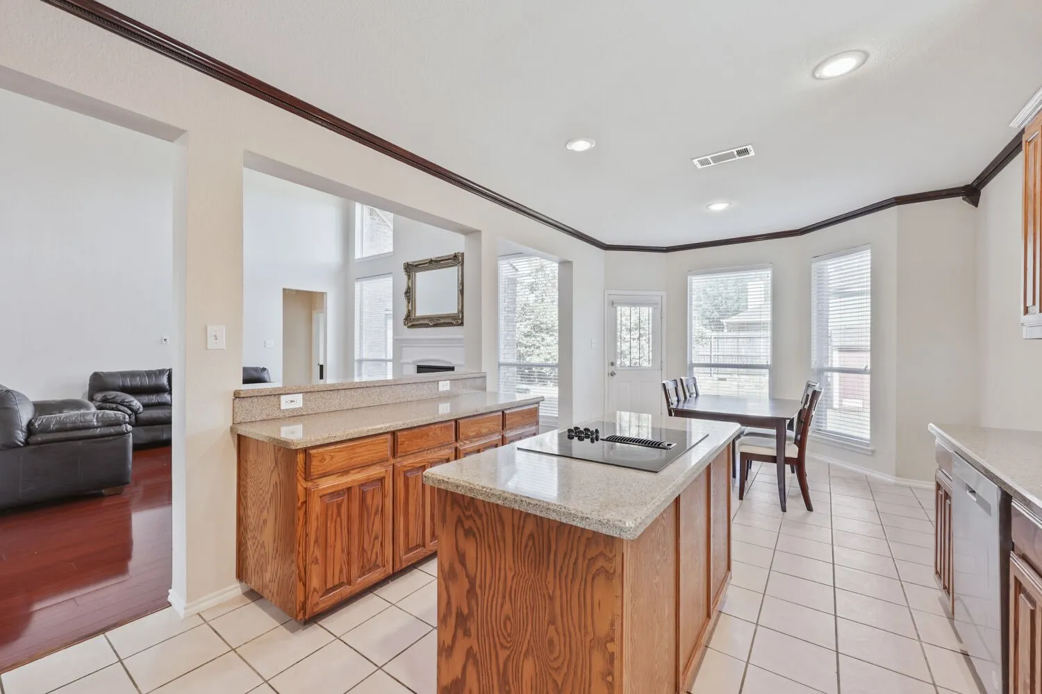 Kitchen featuring a built-in cooktop, light-toned countertops, and wood cabinetry