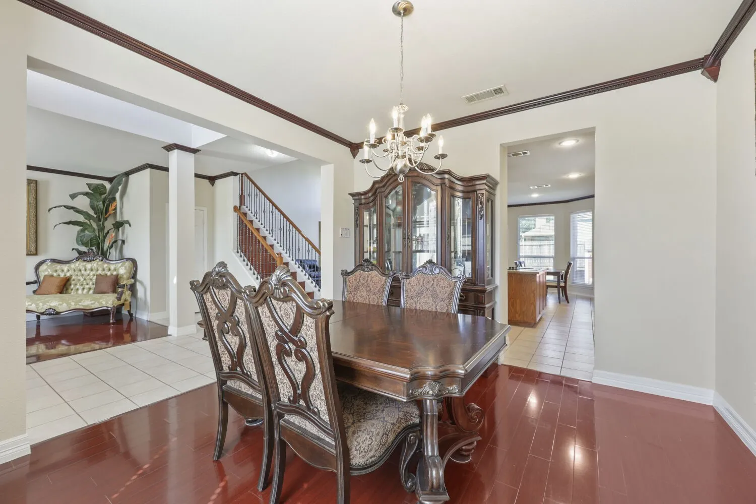 Formal dining space featuring wood-finish flooring, a chandelier light fixture, and decorative crown molding