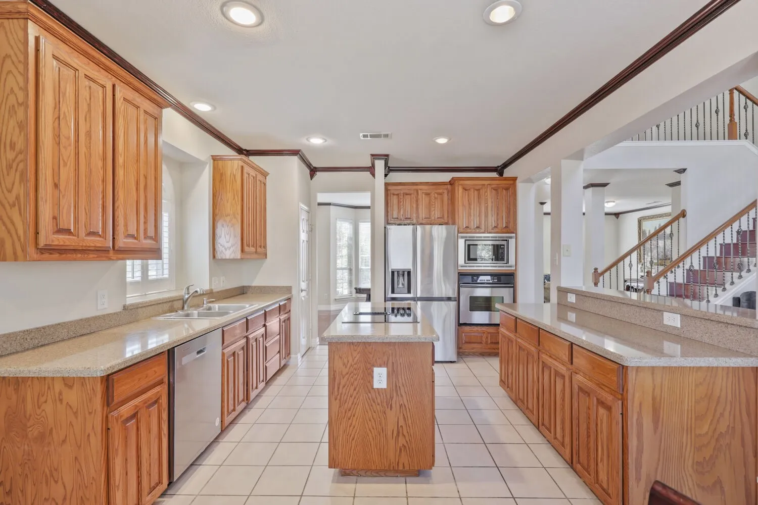 Kitchen with wood cabinetry, light-toned countertops, and stainless steel appliances