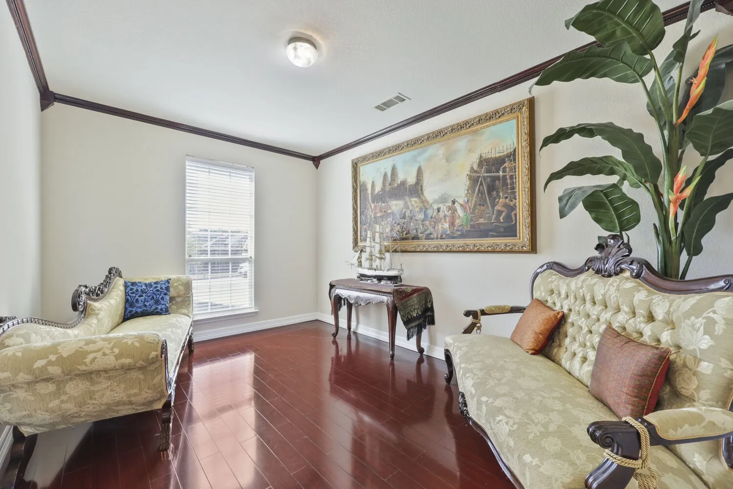 Wood-finish flooring, crown molding, a window with blinds, and a flush mount ceiling light