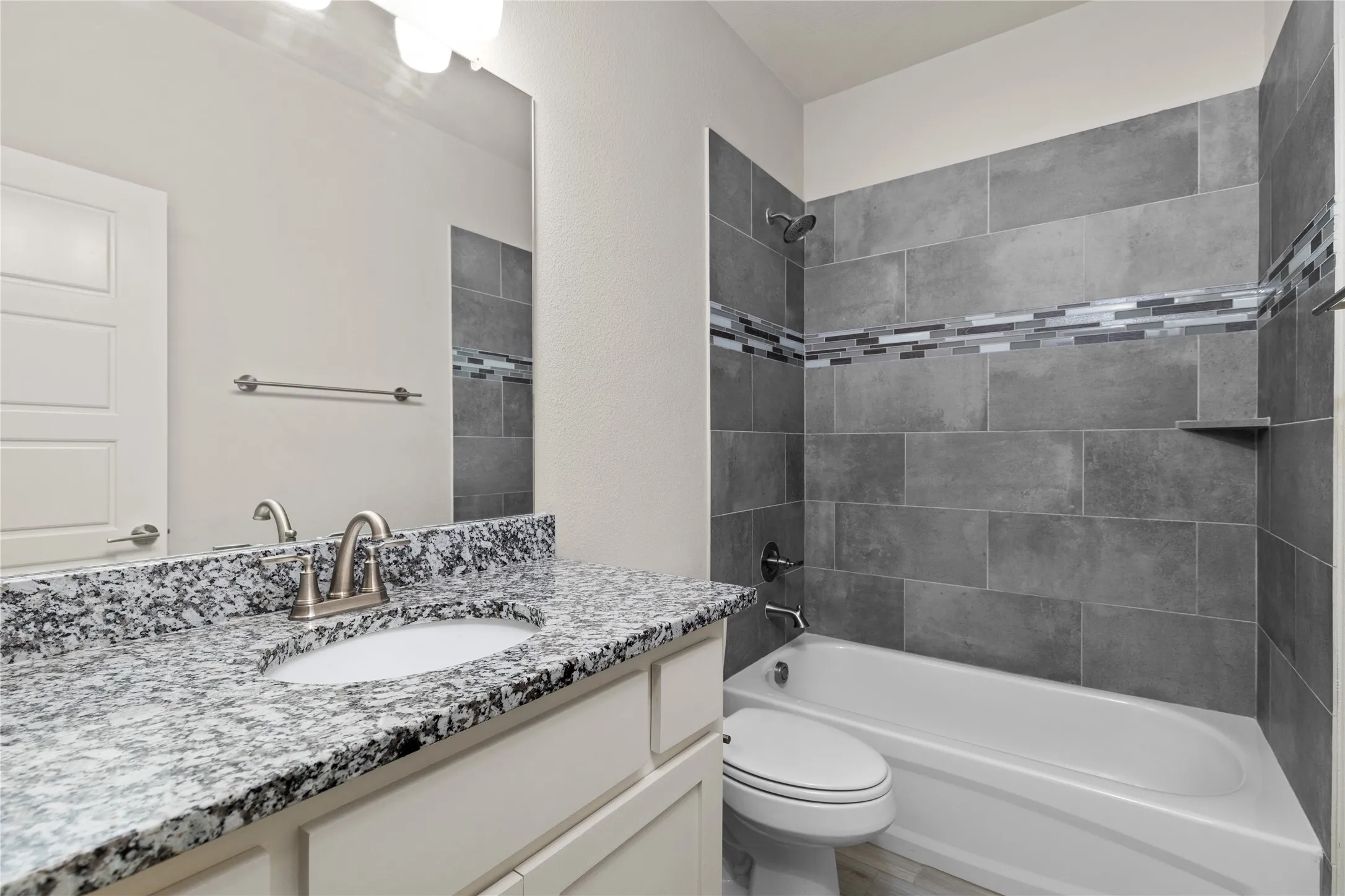Vanity with a speckled countertop, undermount sink, and brushed nickel faucet