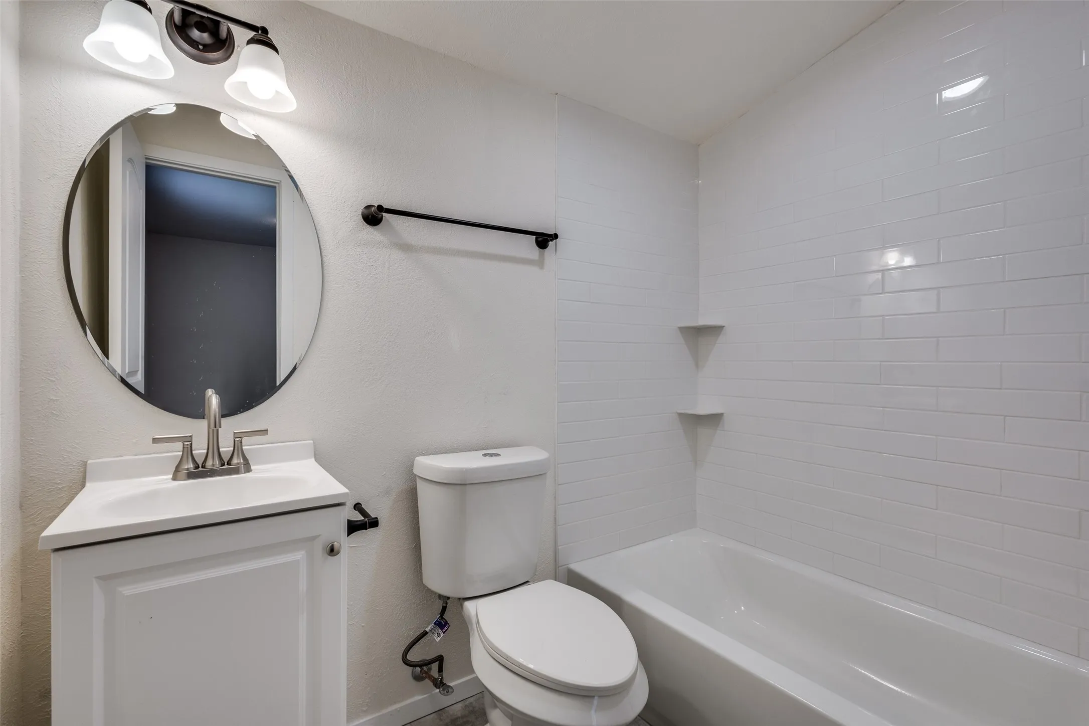 Full bathroom featuring tiled shower / bath, toilet, and vanity