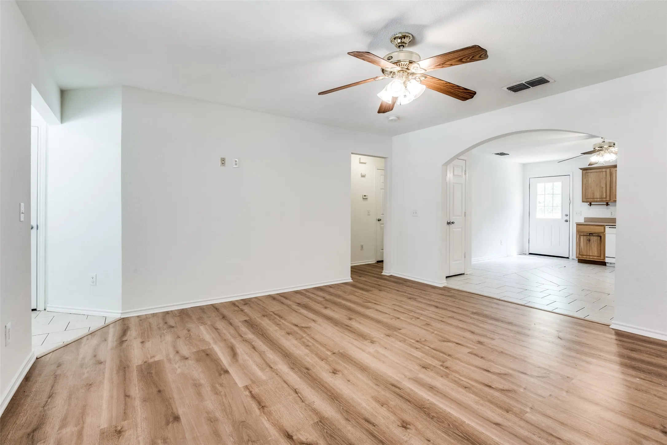 Unfurnished living room with ceiling fan and light hardwood / wood-style flooring