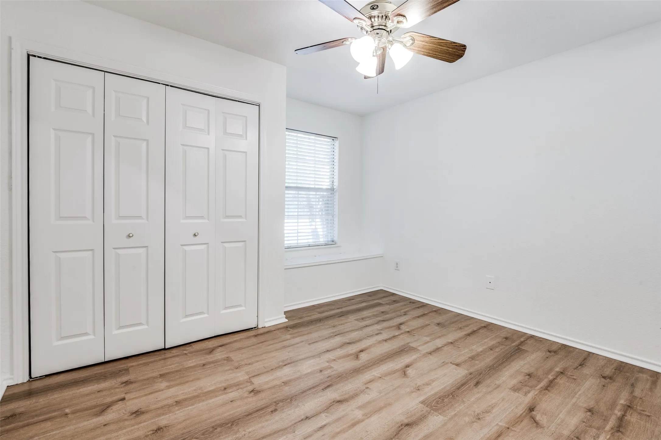 Unfurnished bedroom featuring light wood-type flooring, ceiling fan, and a closet