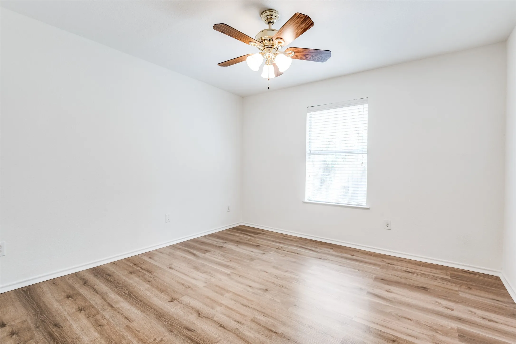 Unfurnished room featuring light wood-type flooring and ceiling fan
