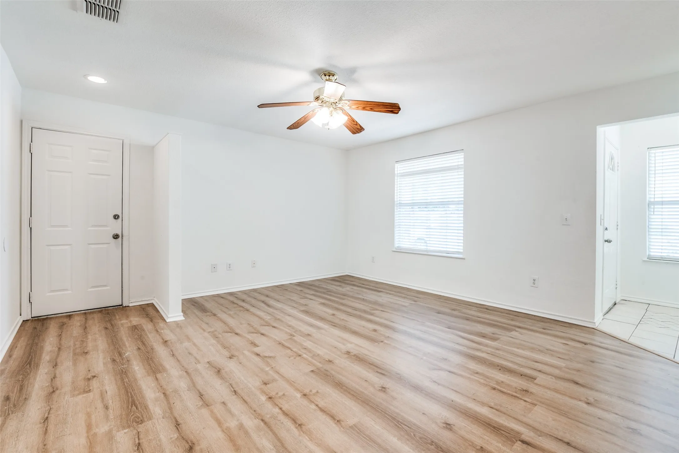 Unfurnished room with a healthy amount of sunlight, ceiling fan, and light hardwood / wood-style floors