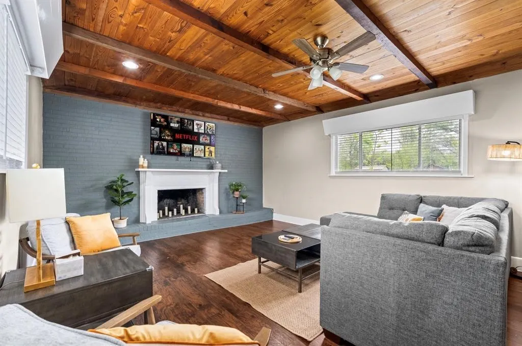 Wood-finish plank and beam ceiling with recessed lighting and a ceiling fan