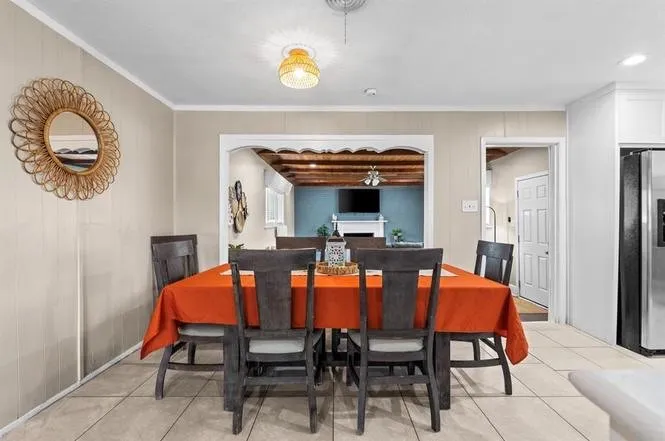 Tiled flooring throughout, light-toned wall paneling, and an arched entryway