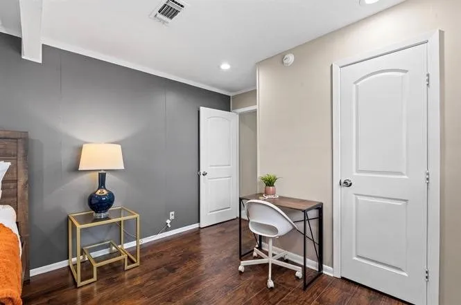 Wood-finish flooring, recessed lighting, and white interior doors with arched paneling