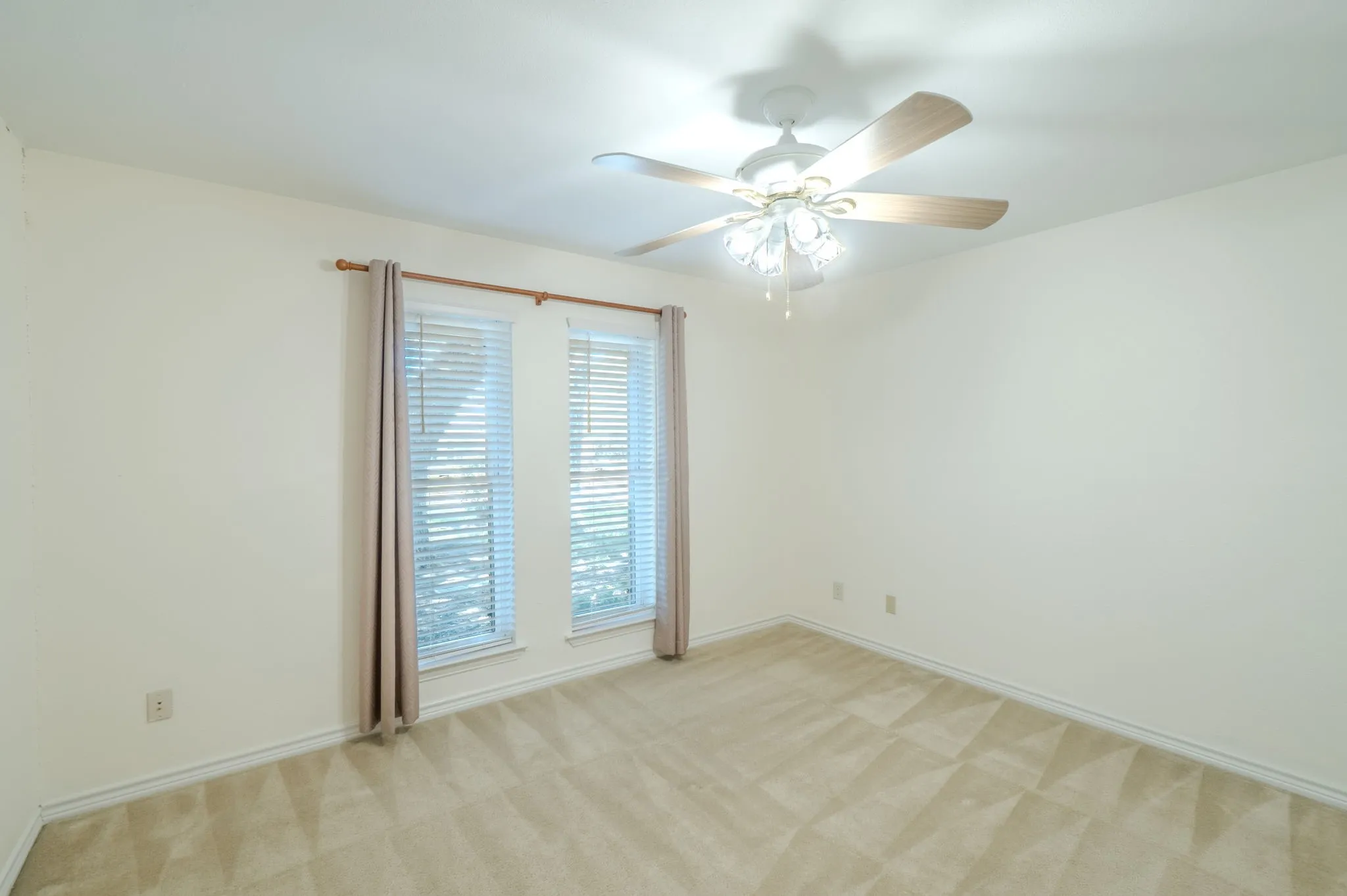 Bed 2 Recessed windows with blinds, ceiling fan with light fixture, neutral wall color, and patterned carpet flooring
