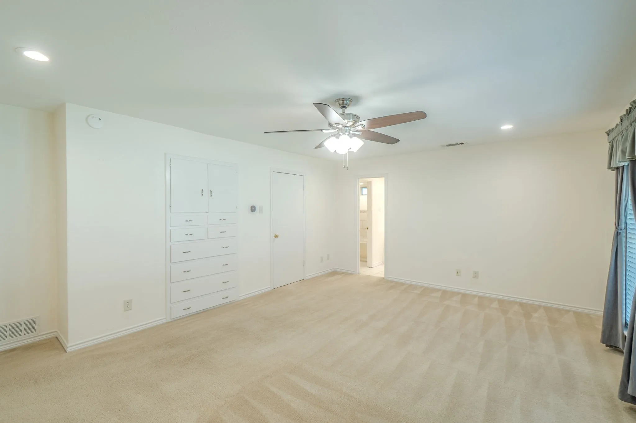 Recessed ceiling lighting, ceiling fan, built-in cabinetry with drawers, and carpeted flooring