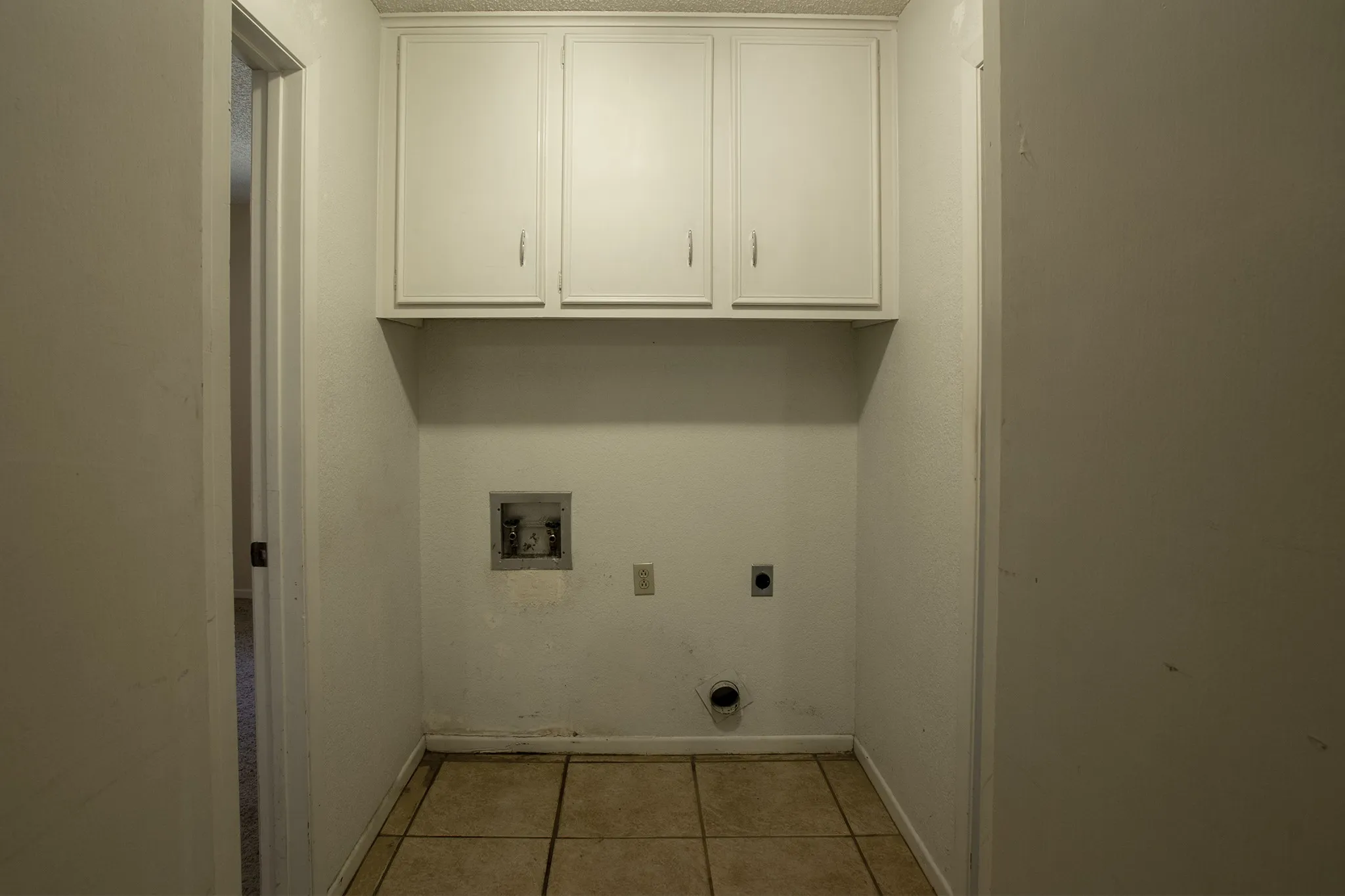 Built-in upper cabinetry, utility hookups, and tiled flooring