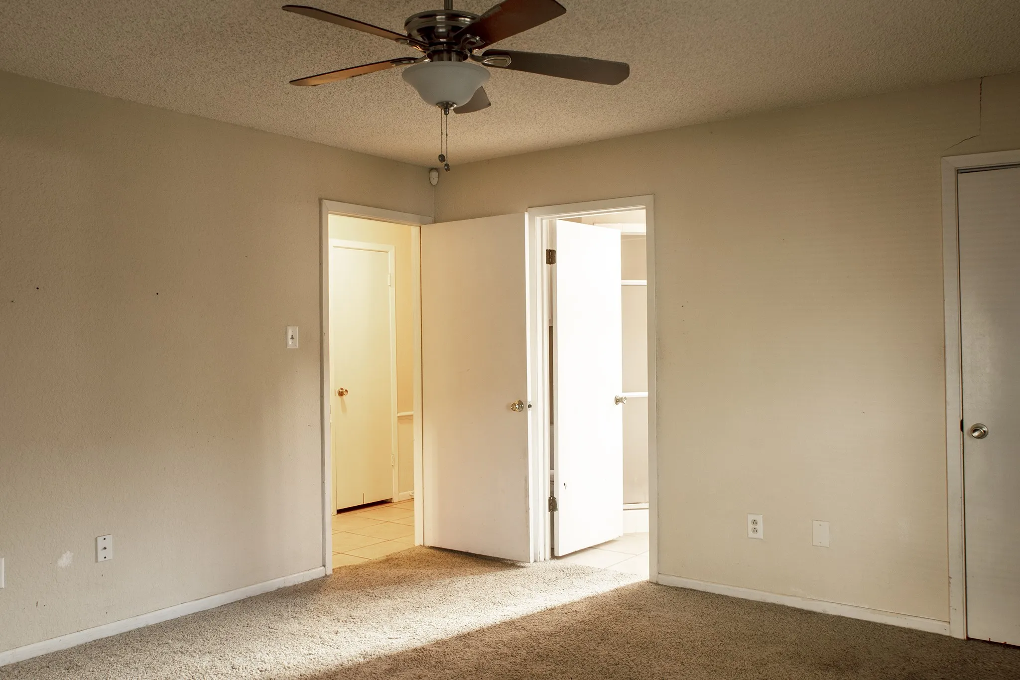 Primary bedroom with separate closet, bathroom, and easy access to front door or patio