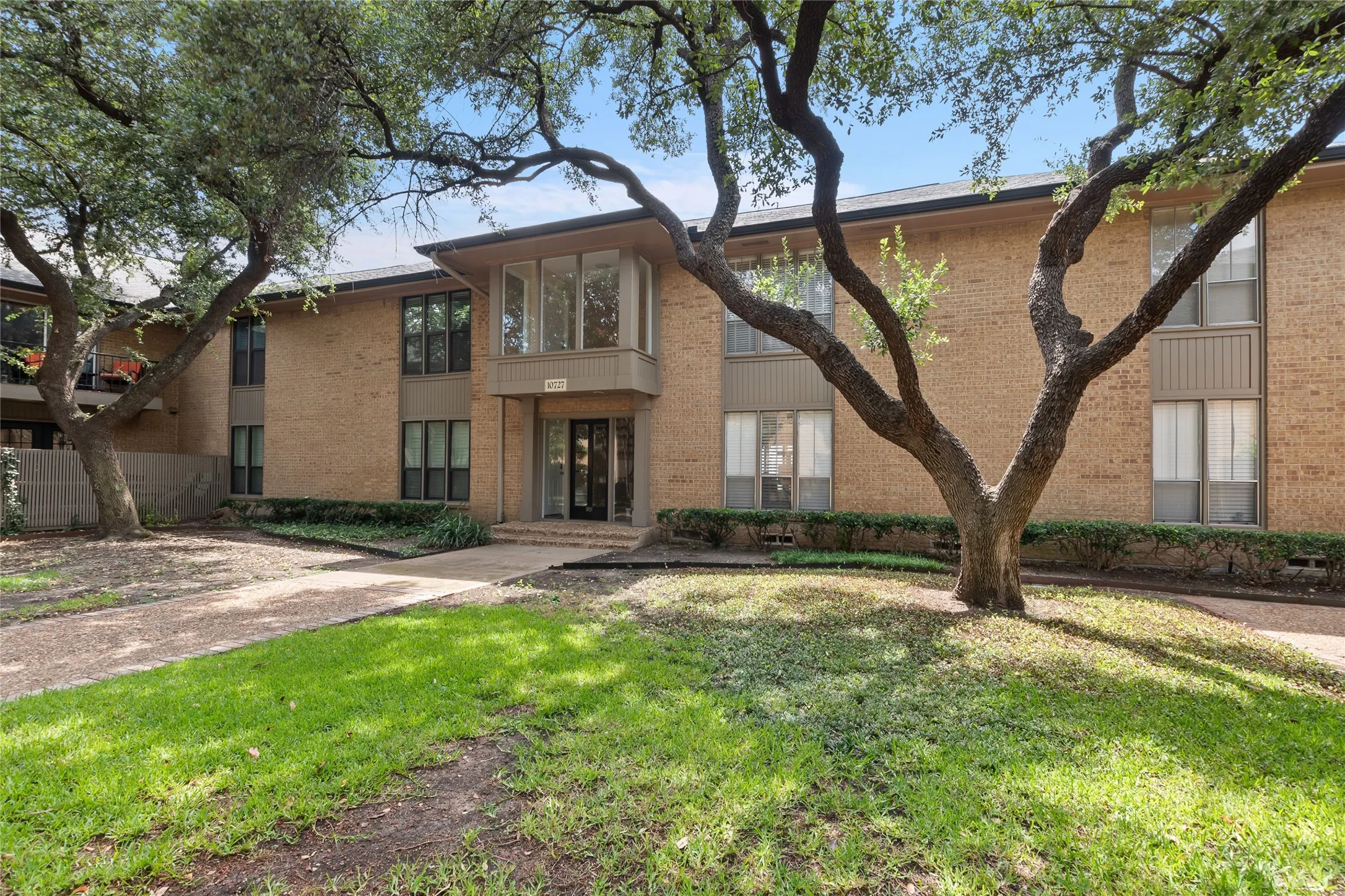 Townhome / multi-family property with brick siding and a front yard