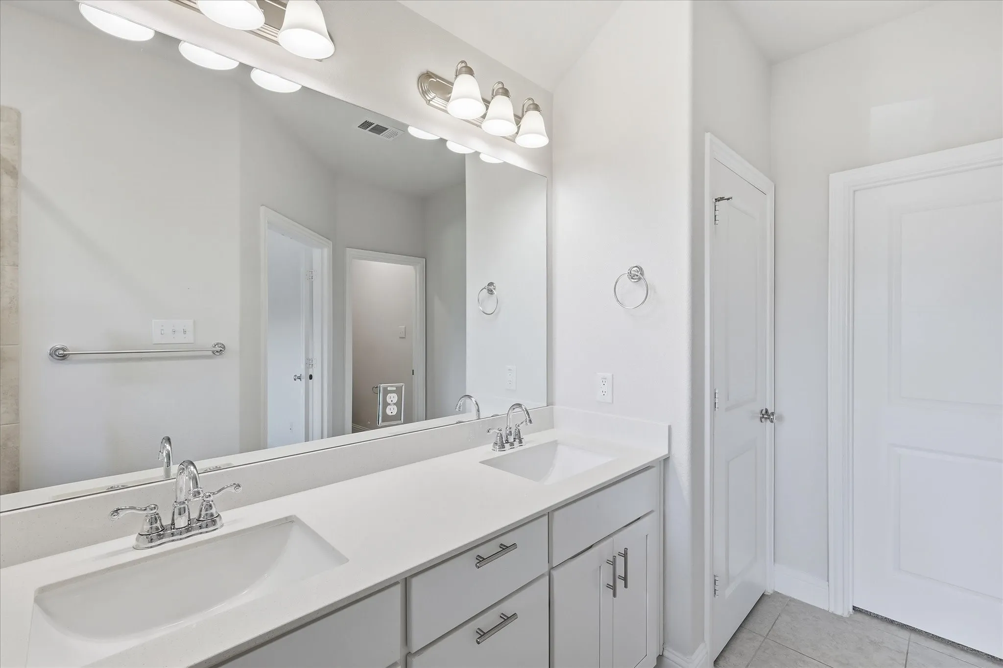 Dual vanity with white countertops, undermount sinks, and chrome faucets