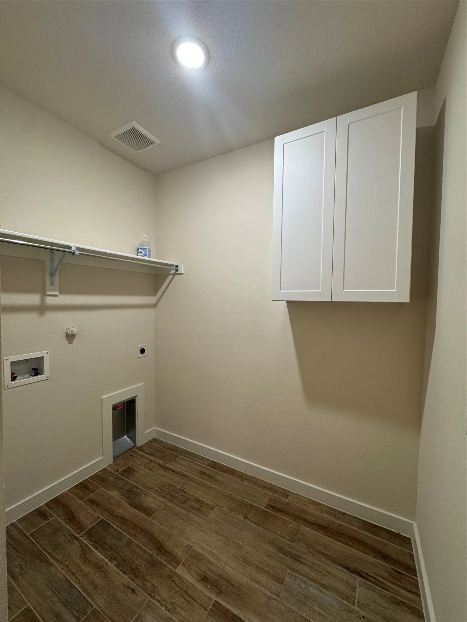 Laundry room with hookup for an electric dryer, wood tiled floors, hookup for a gas dryer, cabinet space, and washer hookup