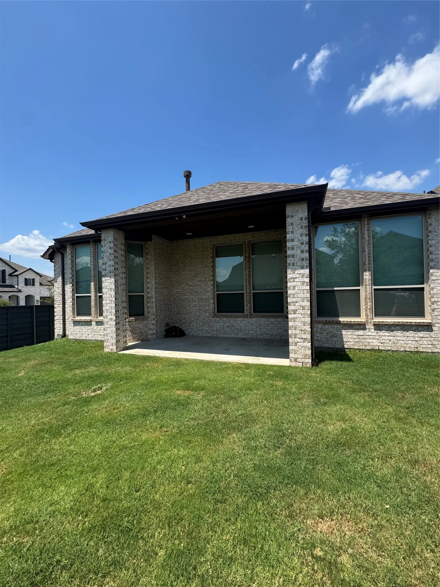 Rear view of property with brick siding and a patio area
