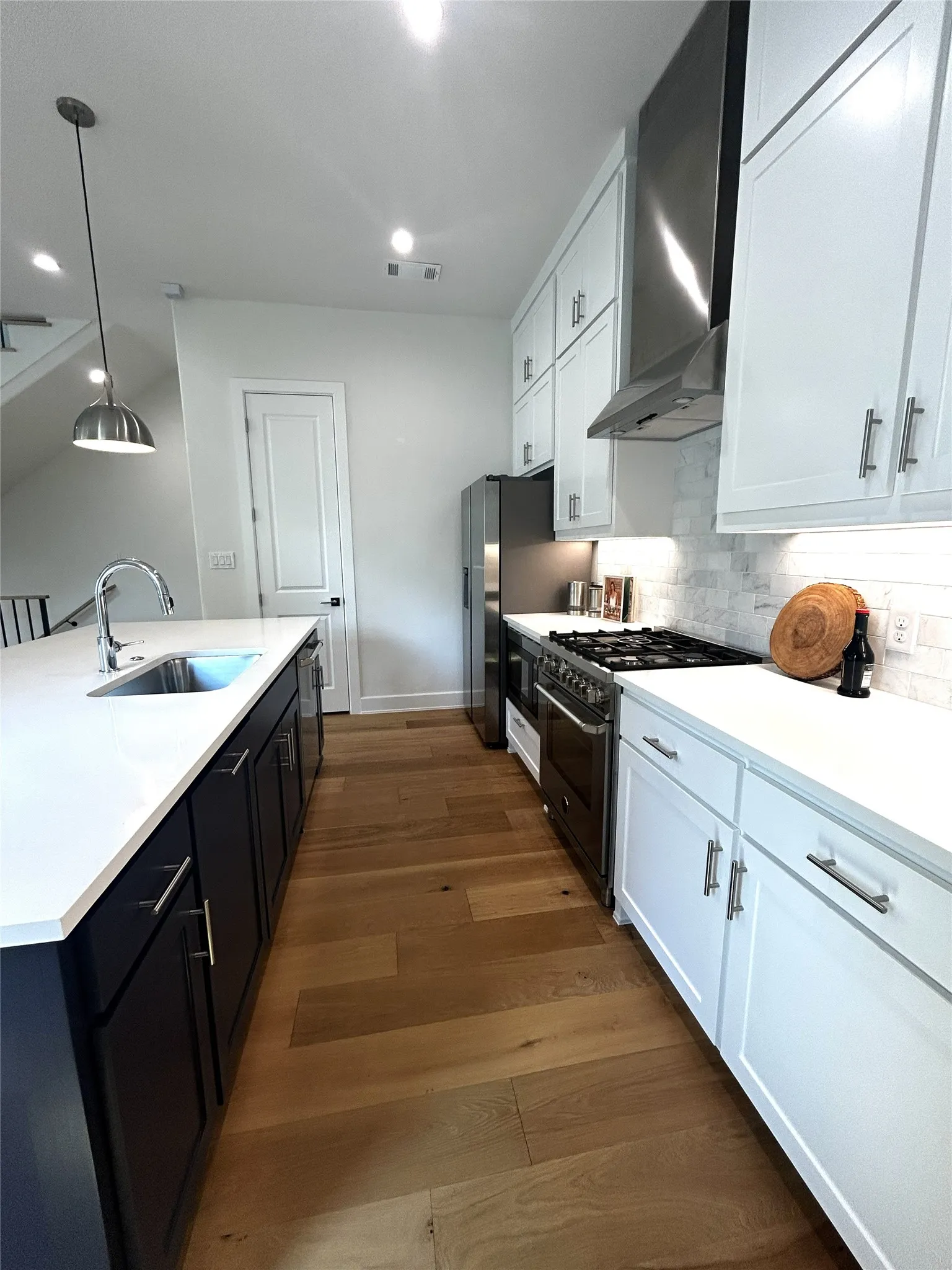 Italian Bertazzoni appliances, designer lighting and huge eat up navy blue island