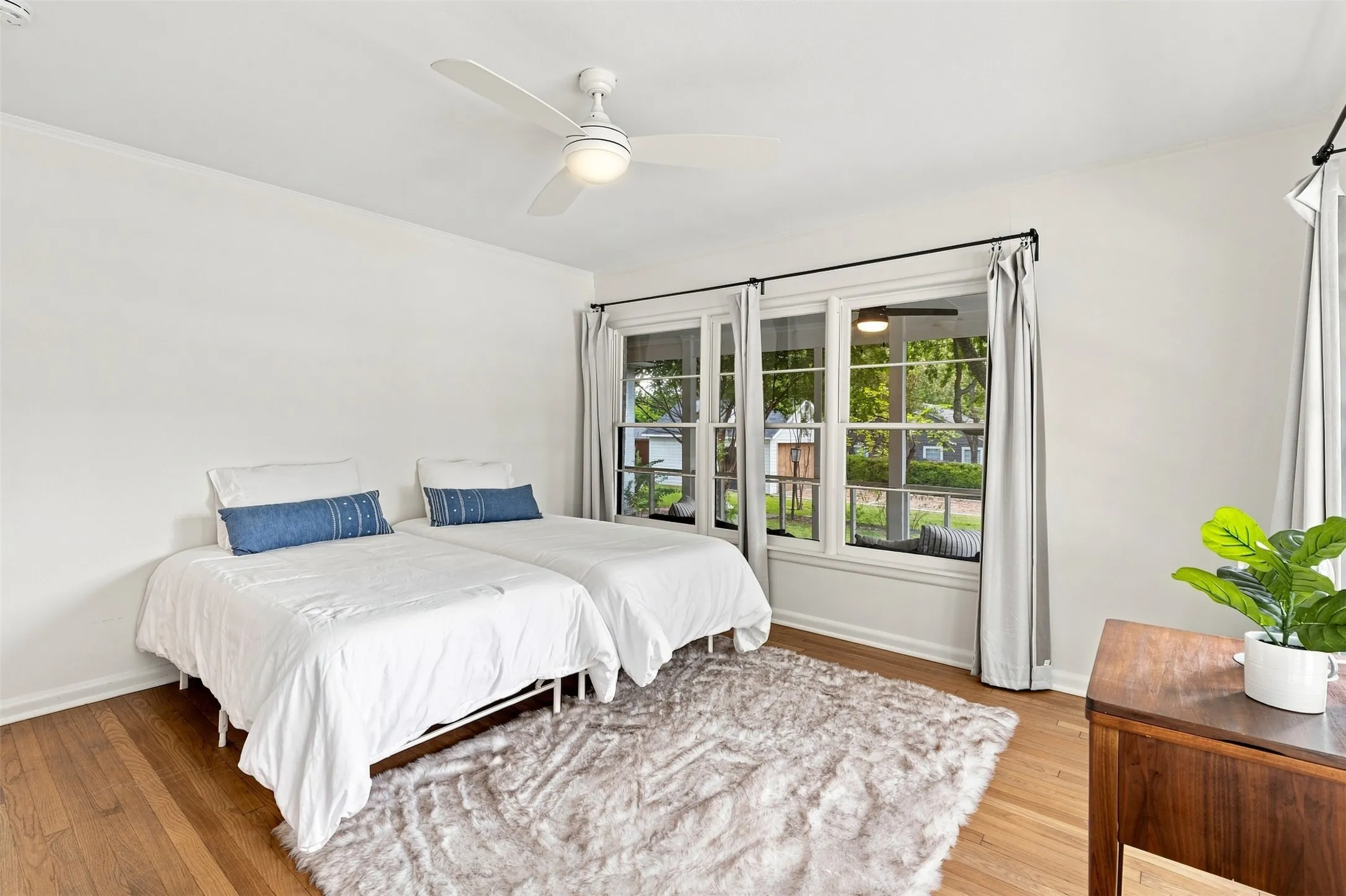 Charming bedroom on the first floor overlooking the sun porch and a view of the tree lined lot.