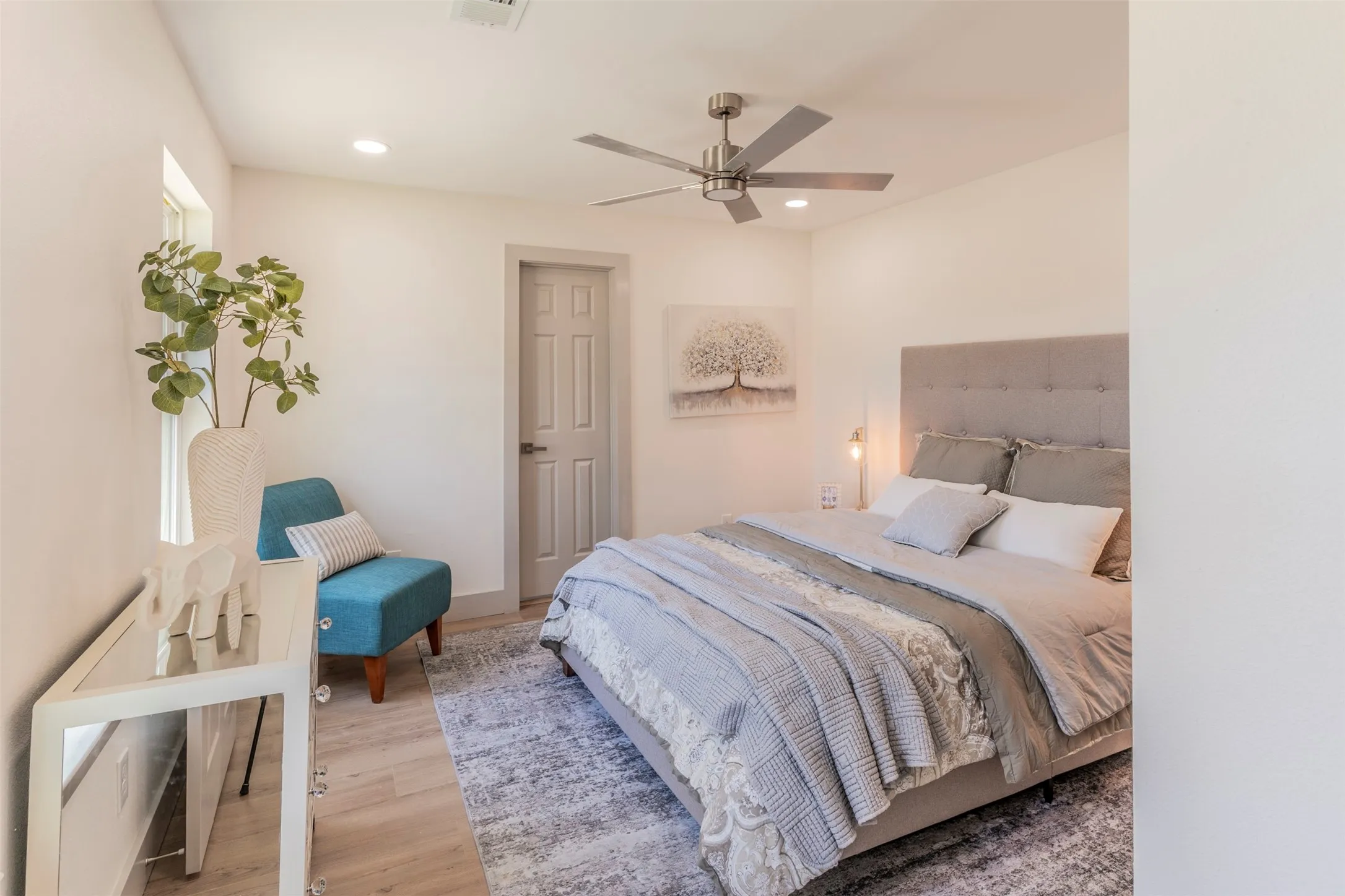 Recessed lighting, ceiling fan, wood-finish flooring, and a paneled interior door