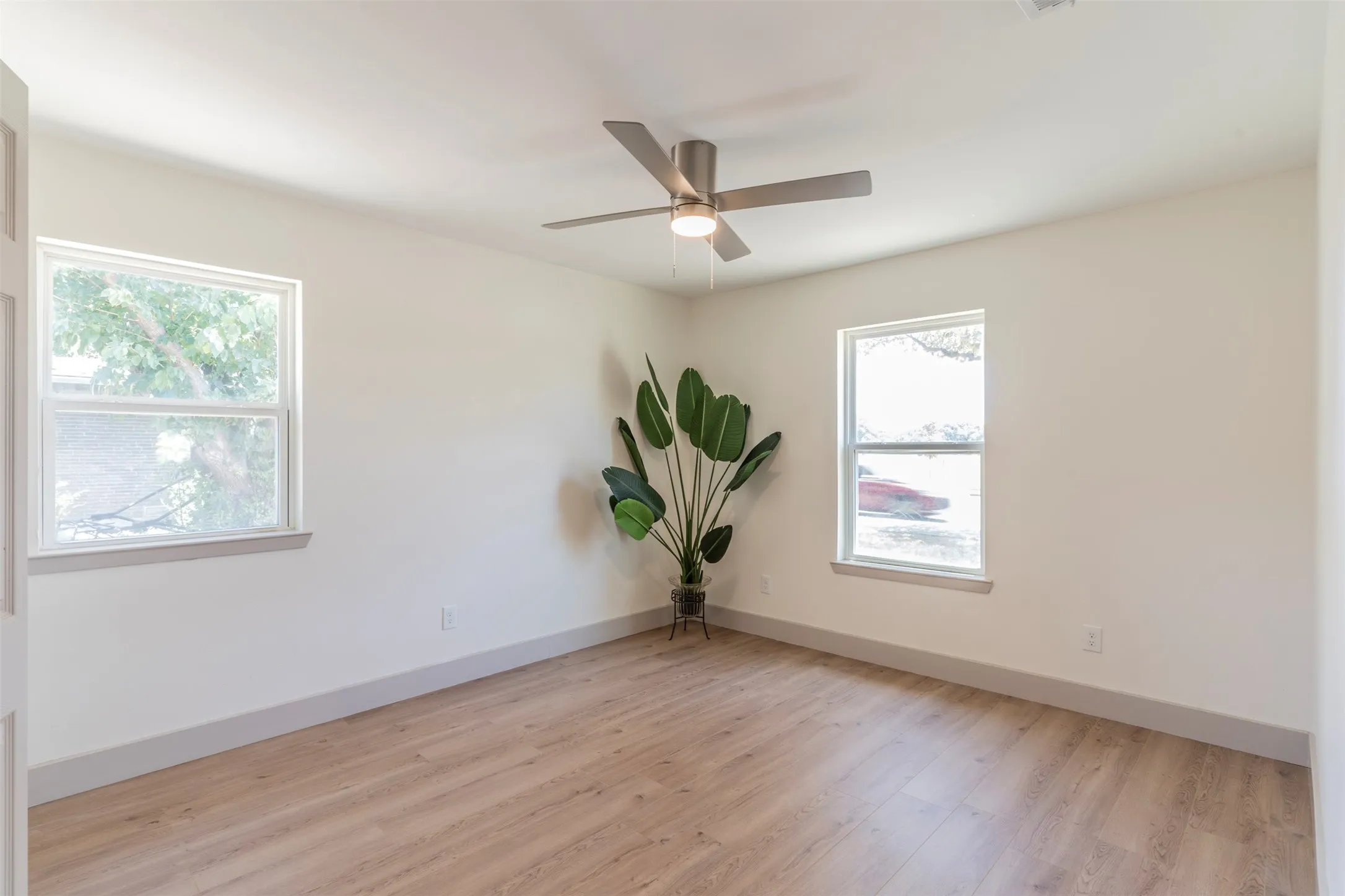Recessed lighting, ceiling fan with light fixture, two double-hung windows, and wood-finish flooring