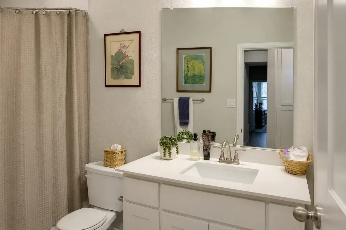 Bathroom featuring a white vanity, integrated sink, brushed nickel faucet, and a large wall-mounted mirror