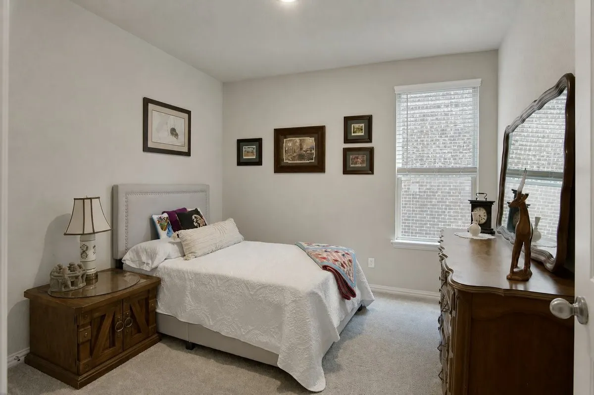 Carpeted room with a single window featuring blinds, a light gray upholstered headboard, and recessed lighting