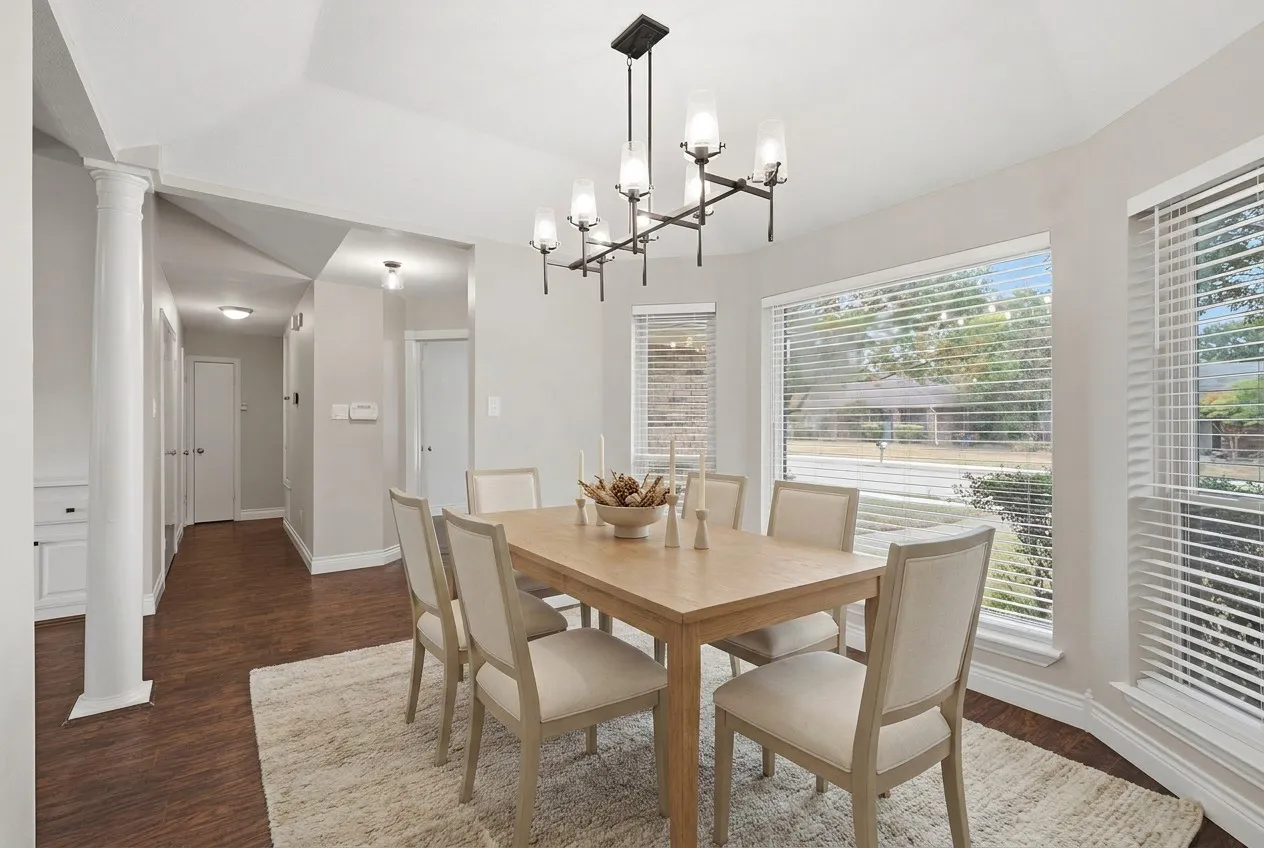 Virtually staged. Dining room with updated, designer lighting, pretty bay windows and great location with ease to the Kitchen.