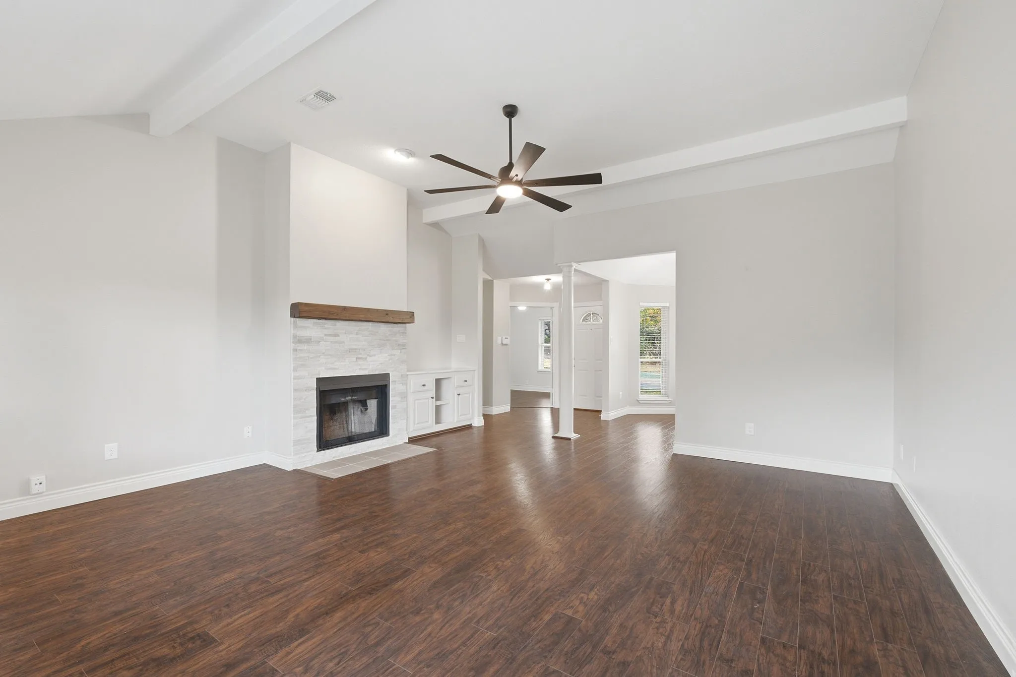 Another view of the living room with views leading toward the front of the home. Note the beams that give a little charcter to the home.