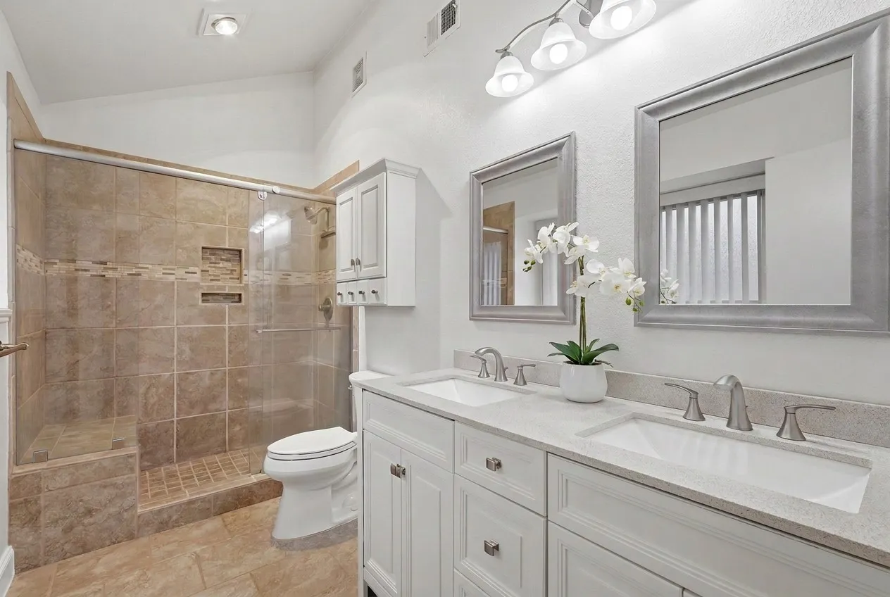 Primary bathroom with dual sinks, new hardware and rimless glass shower door.