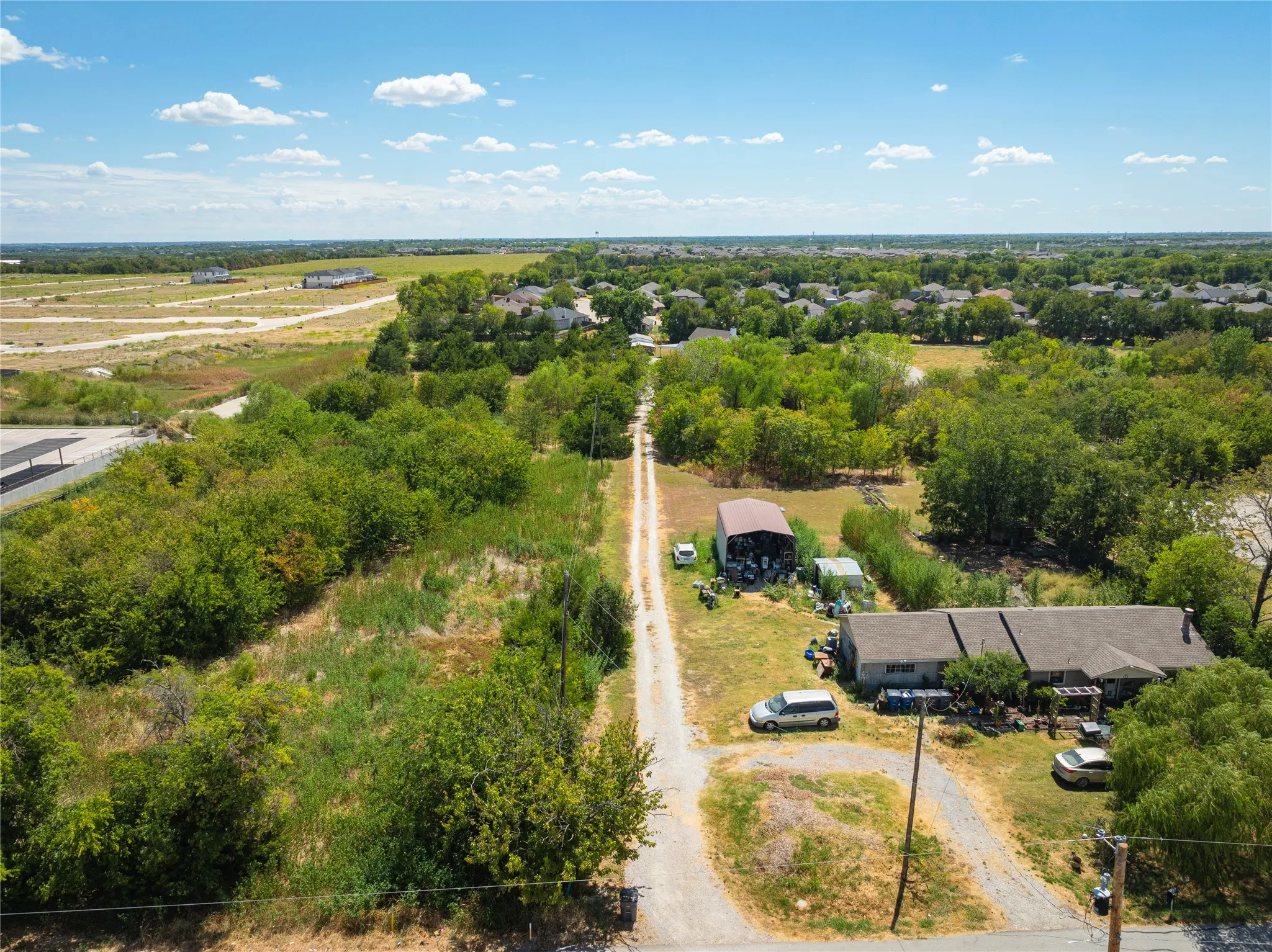 Expansive property with residential structure, detached outbuilding, and established trees