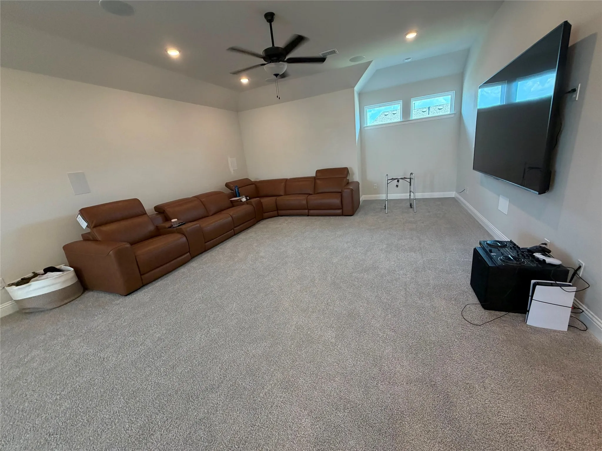 Recessed lighting with a ceiling fan, light-toned carpeting, and transom windows